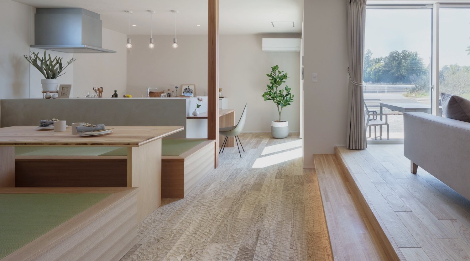 Interior view of a home with natural light, wooden floors and steps between living spaces 