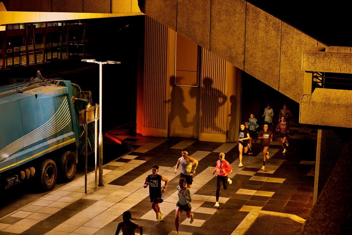 A group of runners in an urban setting, before daylight breaks 